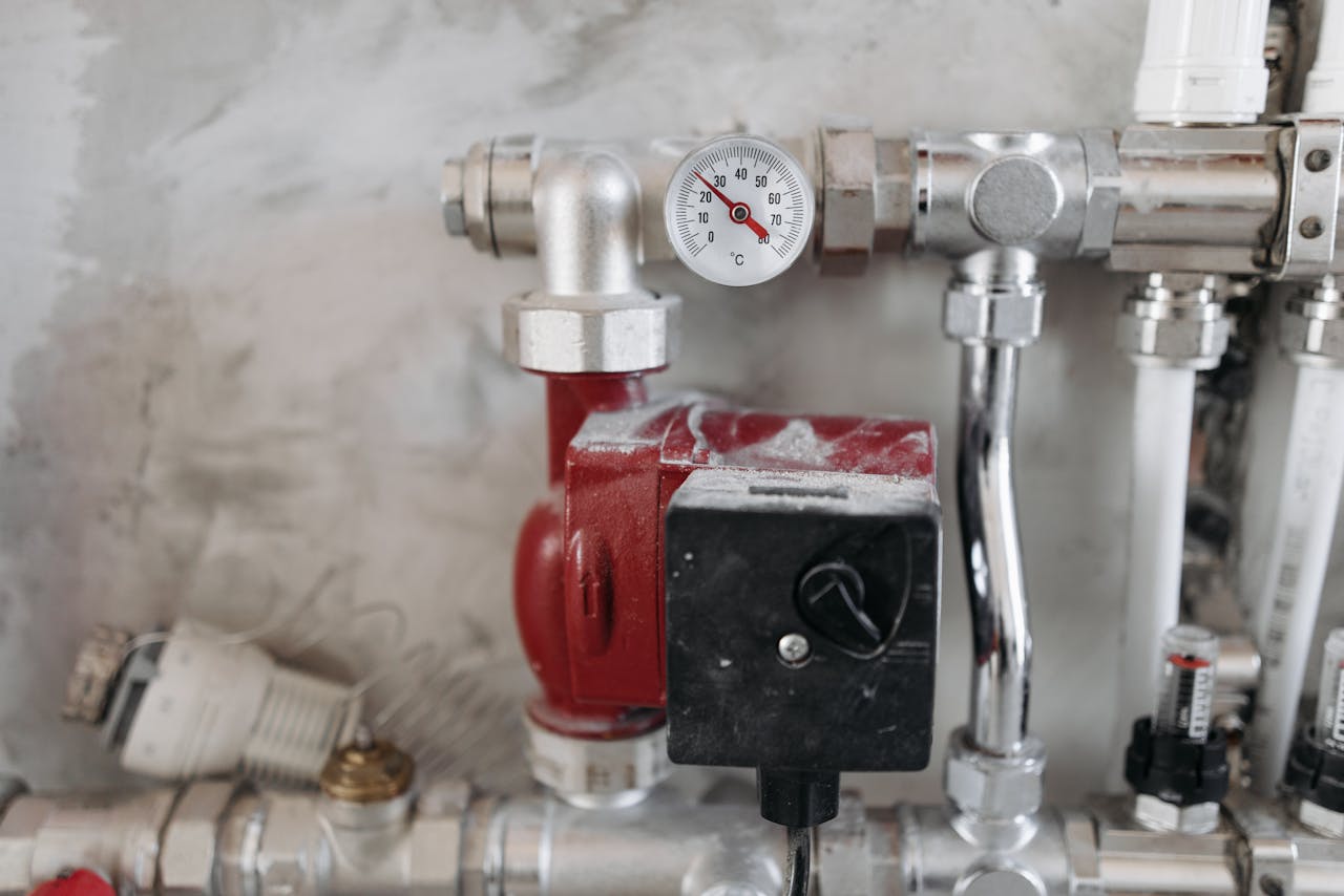 heros-img Close-up view of an industrial plumbing system featuring a pressure gauge and steel pipes.